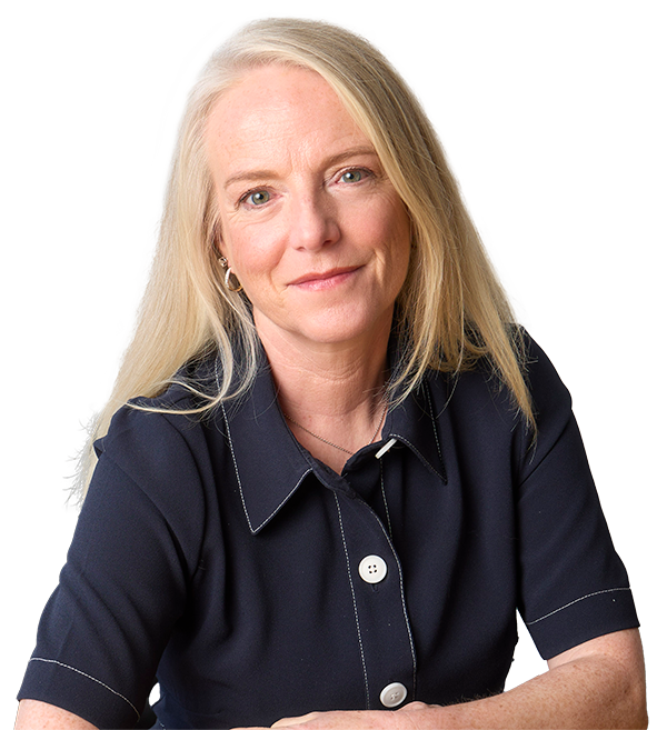 Professional portrait of Catherine Stack, she has long blonde hair and is waring a navy blue short-sleeved blouse with white stitching. She looks calmly at the camera and has her arms gently folded in front of her.